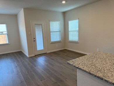 Unfurnished dining area featuring dark wood finished floors and baseboards