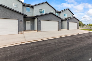 Traditional-style home featuring stucco siding, a garage, and driveway