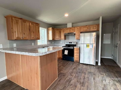 Kitchen featuring freestanding refrigerator, black electric range, under cabinet range hood, dark wood-style flooring, and recessed lighting