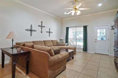 Living room with crown molding, ceiling fan, and l