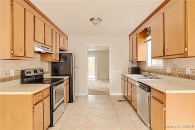 Kitchen featuring under cabinet range hood, light