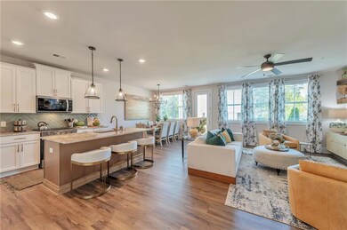 The chef-inspired kitchen showcases elegant countertops, a stylish tiled backsplash, Whirlpool appliances, and a spacious center island