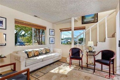Bright and cheery living room with stairs to secon