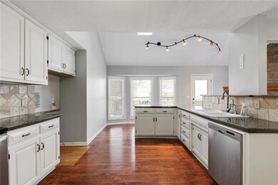 Large kitchen with hardwood floors, open to hearth