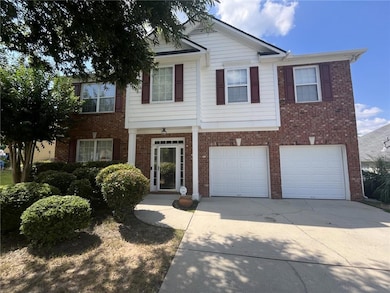 View of front of house with driveway, an attached garage, and brick siding