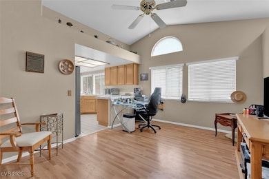 Office featuring lofted ceiling, a ceiling fan, li