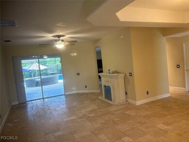Unfurnished living room with a ceiling fan and stone tile floors