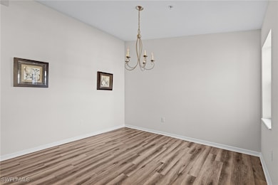 Unfurnished room featuring hardwood / wood-style f