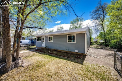 View of front of house featuring a shingled roof, fence, and a vegetable garden
