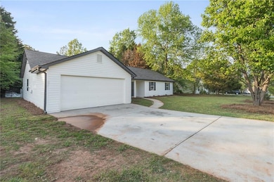 Ranch-style home with an attached garage, a shingl