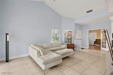 Living area with high vaulted ceiling, visible ven