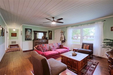 Living room with wood ceiling, visible vents, cro