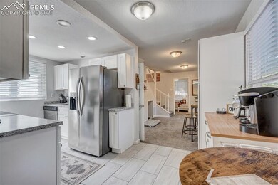 Kitchen with stainless steel fridge with ice dispenser, white cabinets, light countertops, and recessed lighting