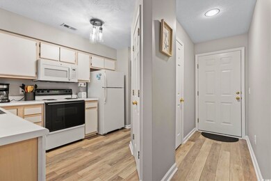 Kitchen with a textured ceiling, light hardwood / 