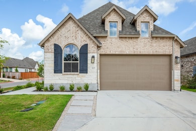 French provincial home featuring driveway, brick 
