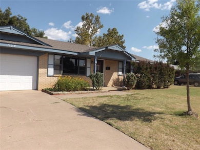 Ranch-style home featuring brick siding, a front lawn, a porch, and driveway