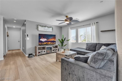 Living area featuring light wood-style flooring and ceiling fan