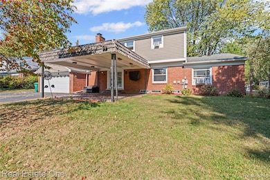 Colonial inspired home featuring brick siding, a patio, a front lawn, and asphalt driveway