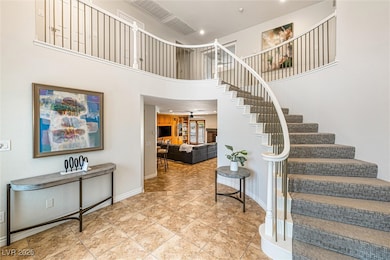 Stairway with a high ceiling, tile patterned flooring, and recessed lighting