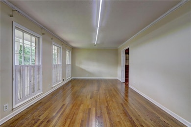 Unfurnished room featuring wood finished floors and crown molding