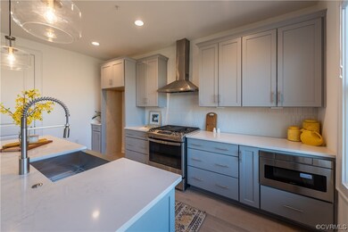 Kitchen features stainless gas range, hood, dishwa
