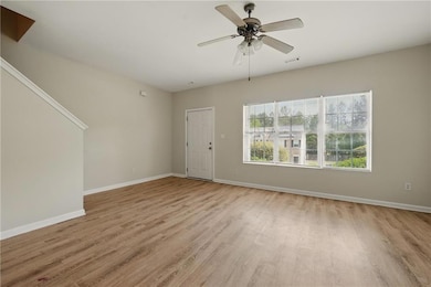 Unfurnished living room featuring baseboards, ligh