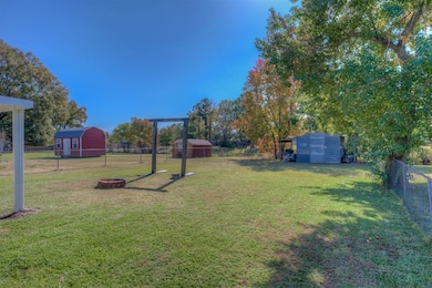 Fenced backyard with a shed and an outdoor fire pit