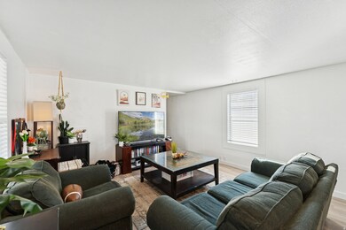 Living room featuring light wood-style flooring and a textured ceiling