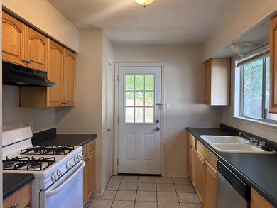 Kitchen featuring dark countertops, white range w
