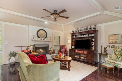 Living room featuring a fireplace, wood-type flooring, lofted ceiling, and ceiling fan
