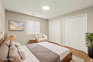 Carpeted bedroom featuring two closets digitally staged for inspiration
