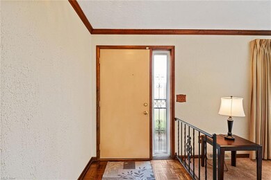 Foyer with light parquet flooring and crown moldin