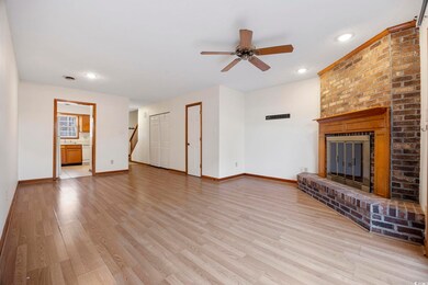 Unfurnished living room featuring a brick fireplac
