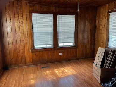 Empty room with wooden walls, light wood-style flo