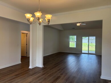 Empty room featuring a chandelier, crown molding, dark wood-style floors, baseboards, and a ceiling fan