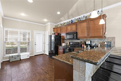 Kitchen featuring black appliances, brown cabinetr