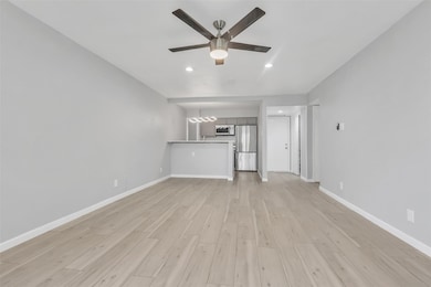 Unfurnished living room featuring ceiling fan and 