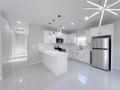 Kitchen with appliances with stainless steel finishes, light countertops, a peninsula, recessed lighting, and white cabinets