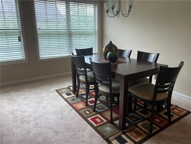 Dining area with carpet flooring, baseboards, and a chandelier