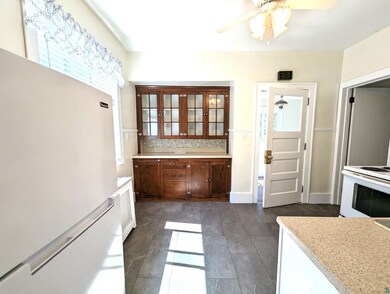 Kitchen with ceiling fan, white appliances, and de