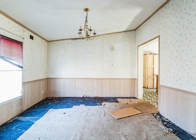 Spare room with a wainscoted wall, crown molding, 