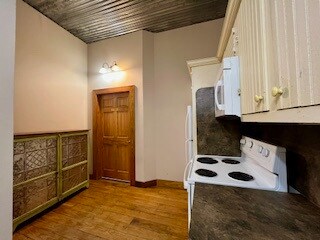 Kitchen featuring white appliances and wood floors