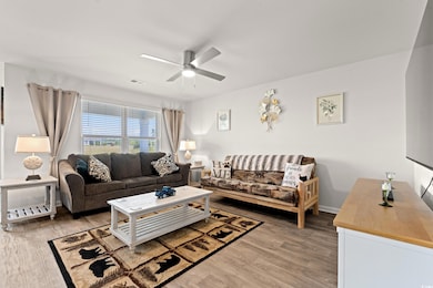 Living room with light wood finished floors and ceiling fan