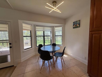 Dining space with light tile patterned floors, ba