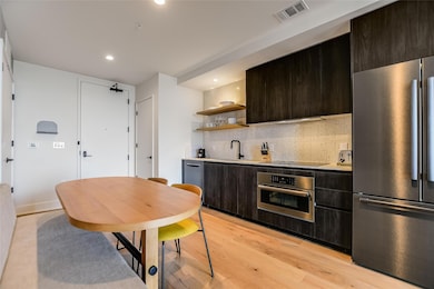 Kitchen with backsplash, visible vents, appliance