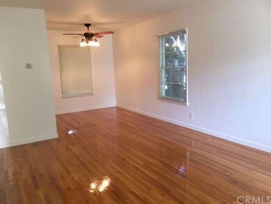 Living dining combo with beautiful hardwood floors and ceiling fan.