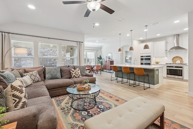 Living area with light wood look tile, recessed lighting, and a ceiling fan