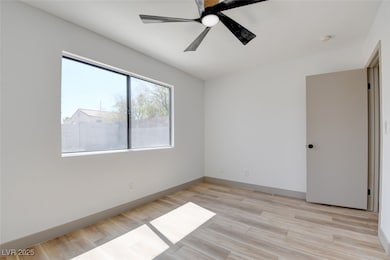 Spare room featuring a ceiling fan, light wood-typ