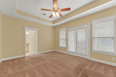 This spacious primary bedroom has doors to your pr