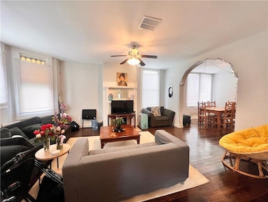 Sunny Living room with bay window and decorative fireplace. Gorgeous hardwood floors.